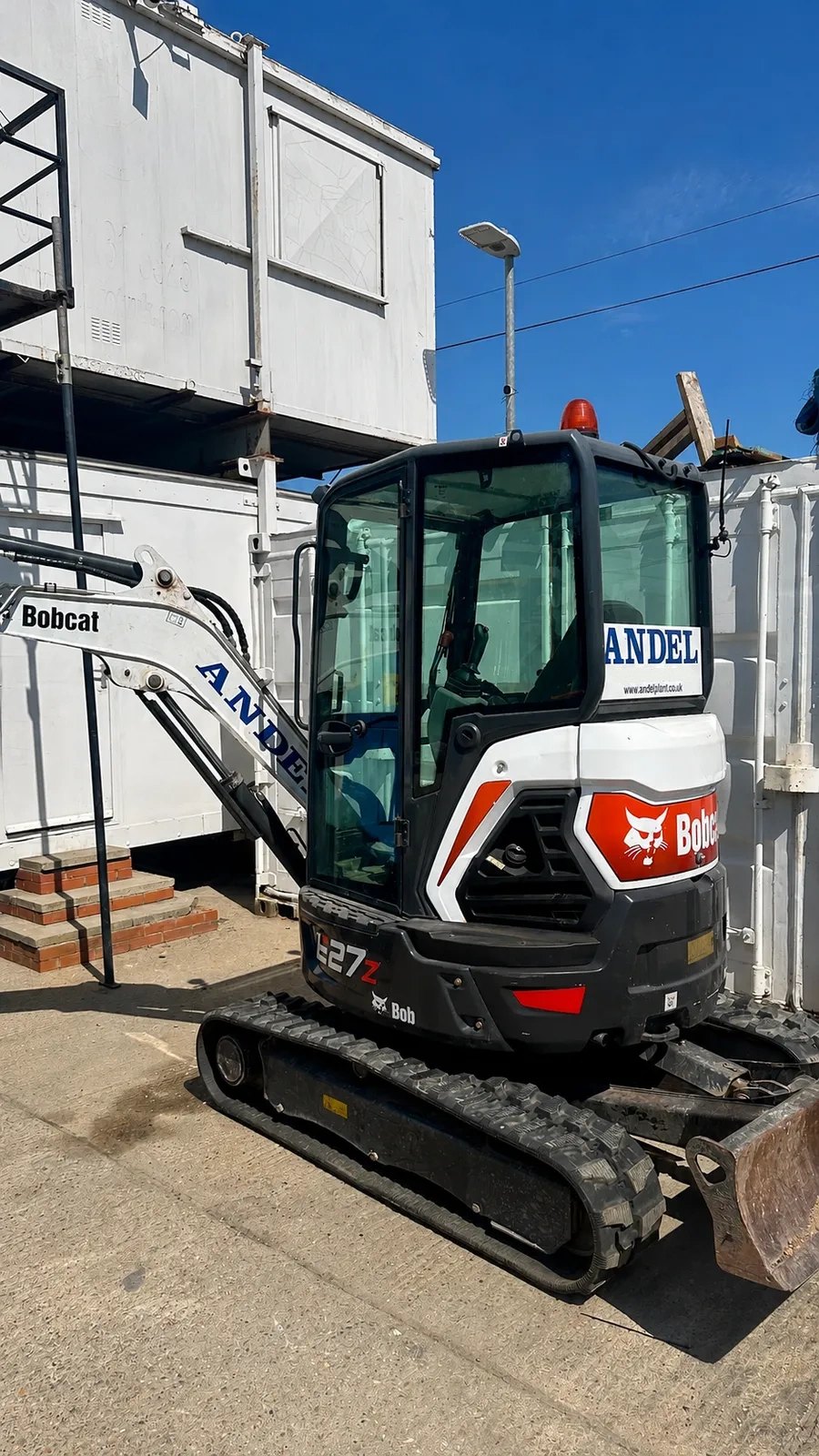 Bobcat mini excavator parked at a site compound
